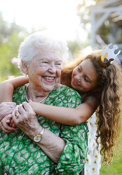 grandaughter hugging her grandma from behind