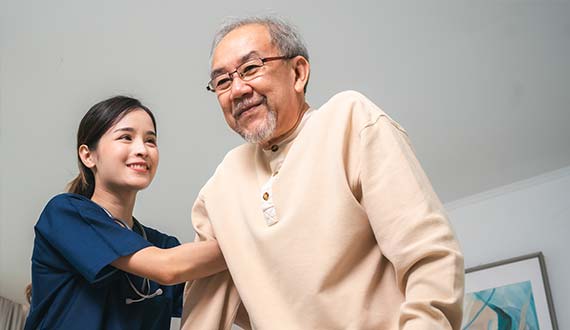 nurse helping elderly man